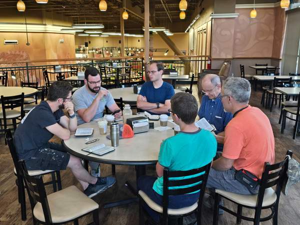 Men's Bible study group around a table with open Bibles