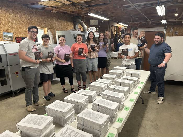 Church members holding finished printed Scriptures ready for the mission field