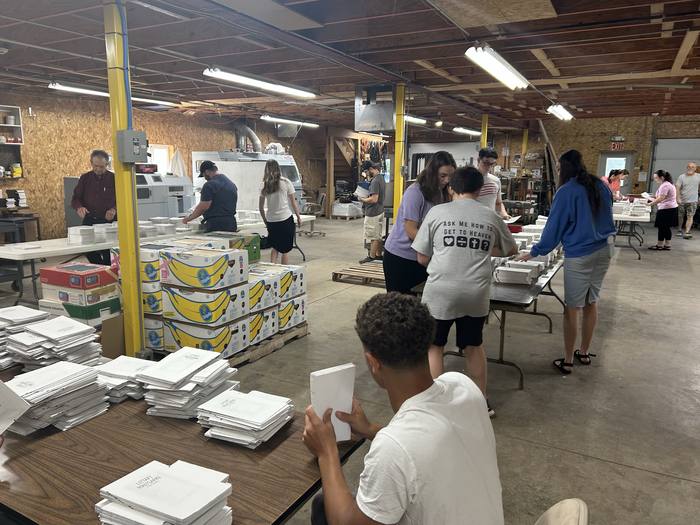 Church members assembling printed Scriptures at work tables
